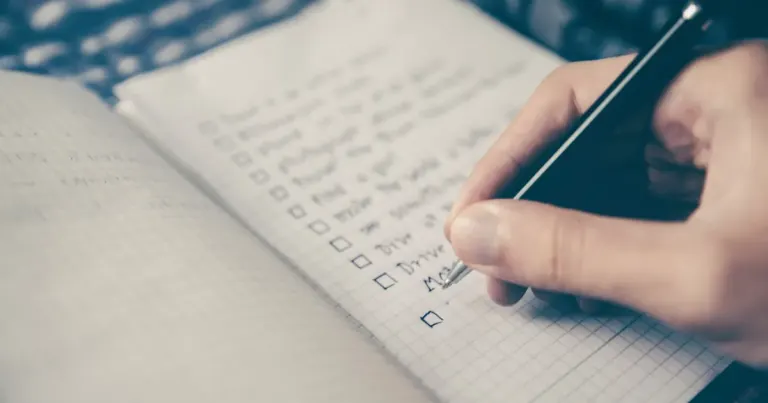 Hand filling in a checklist in a notebook