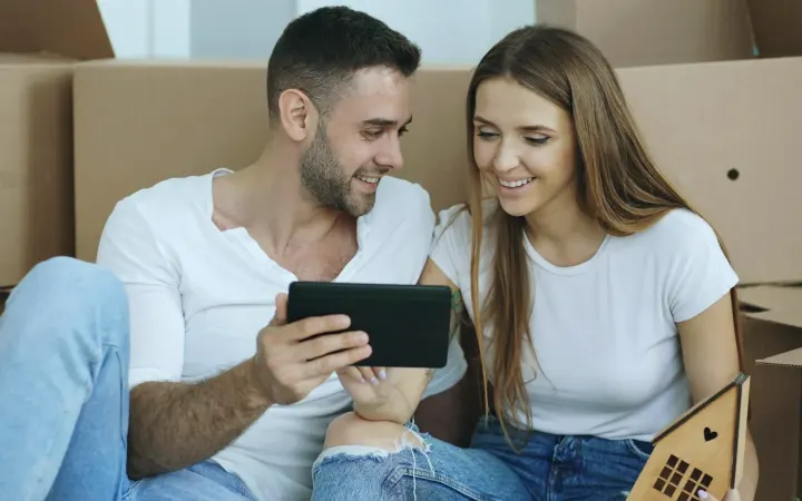 Ζευγάρι ανάμεσα σε κούτες μετακόμισης οργανώνει τη μετακόμιση του σπιτιού του